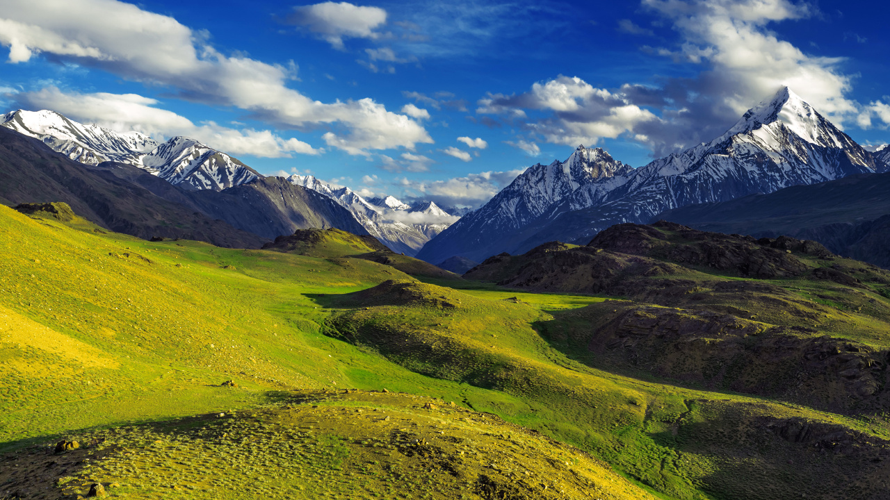 Green Grass Field Near Mountains Under Blue Sky During Daytime. Wallpaper in 1280x720 Resolution