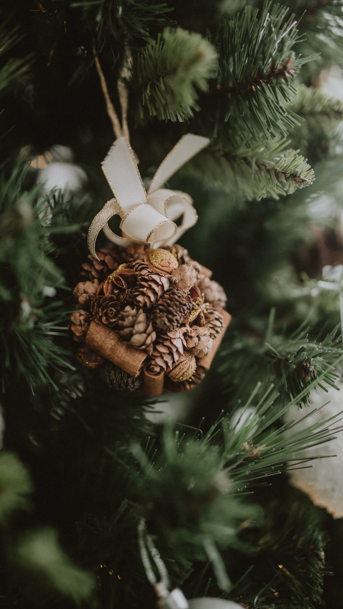 Brown Pine Cone on Green Christmas Tree. Wallpaper in 1440x2560 Resolution