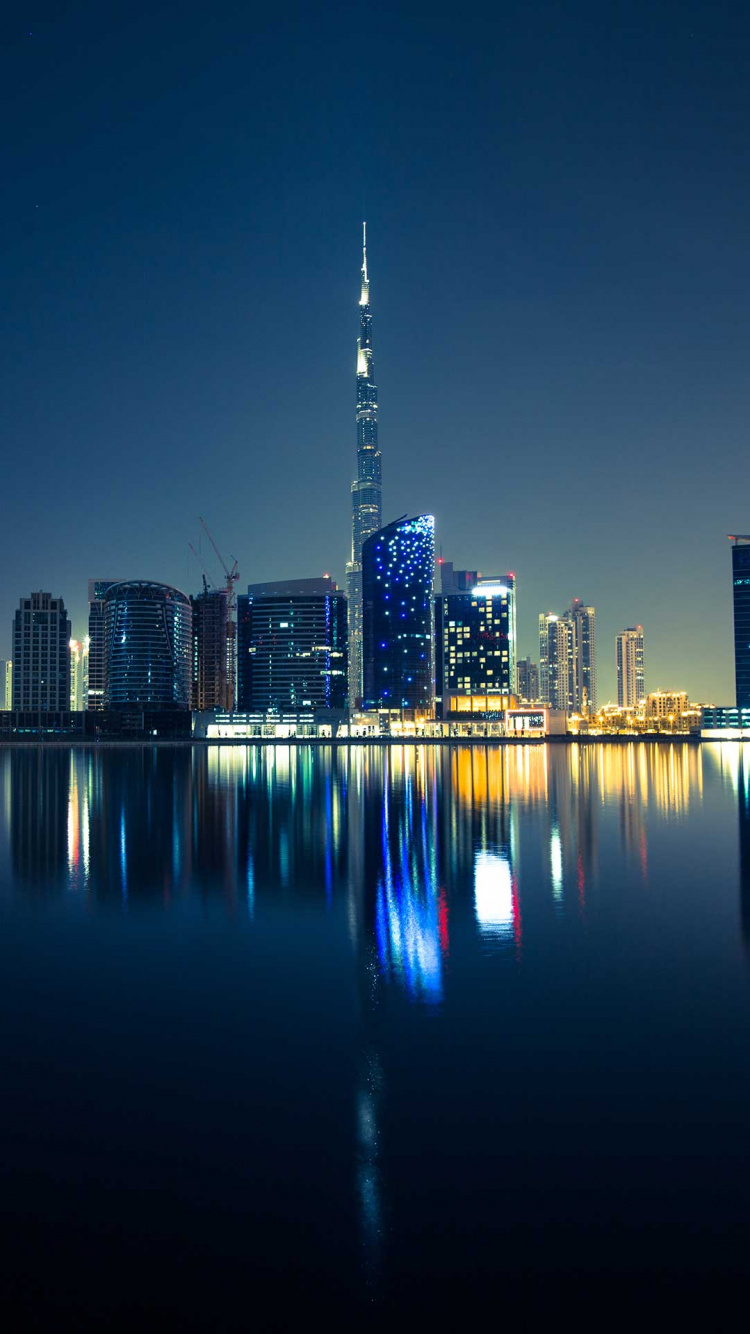 City Skyline Across Body of Water During Night Time. Wallpaper in 750x1334 Resolution