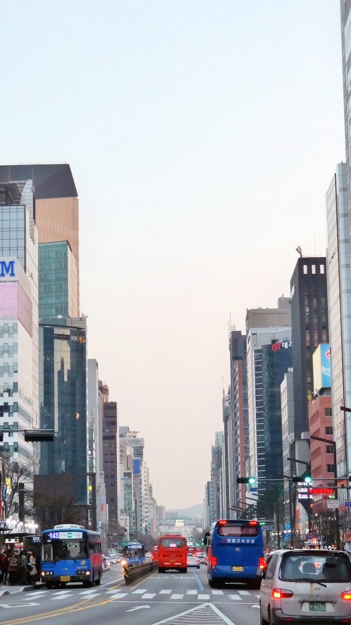 Cars on Road Between High Rise Buildings During Daytime. Wallpaper in 720x1280 Resolution