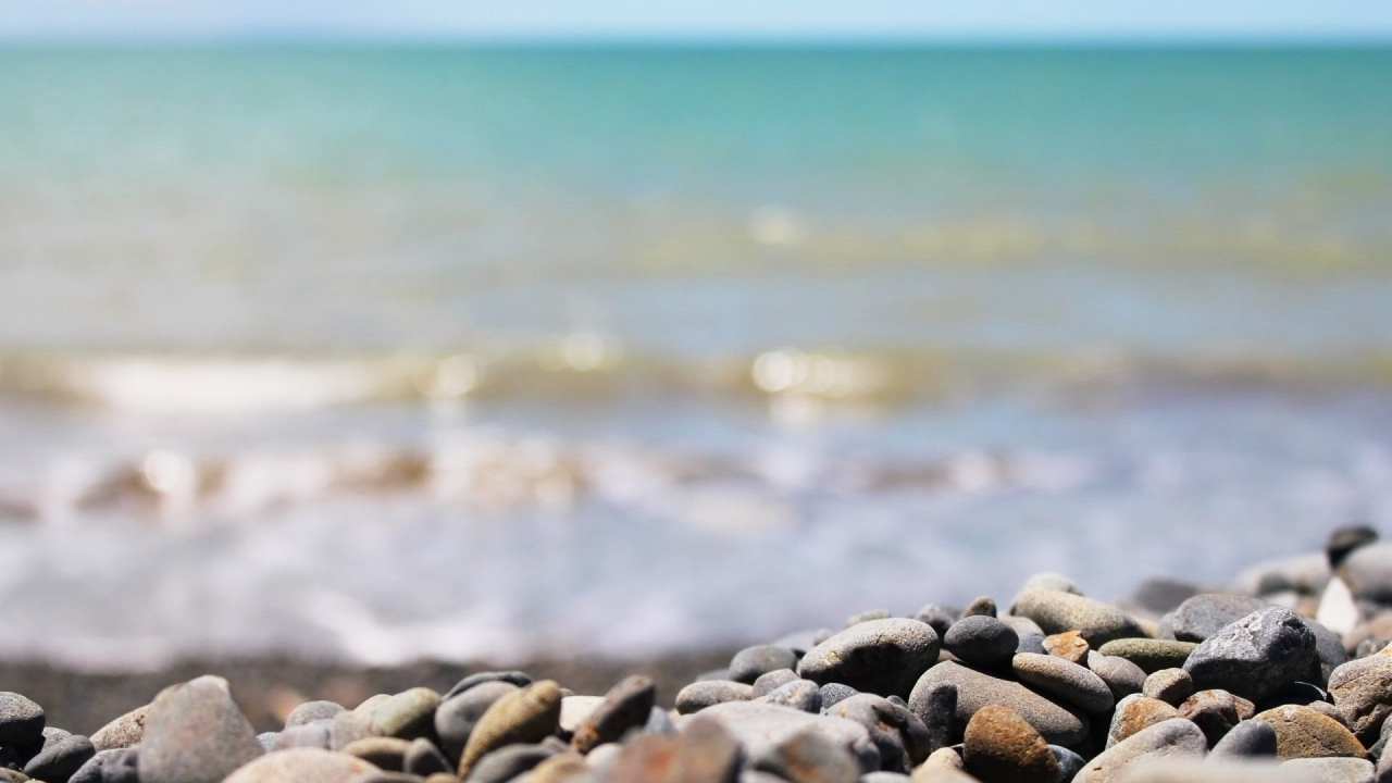 Brown and Gray Stones Near Body of Water During Daytime. Wallpaper in 1280x720 Resolution