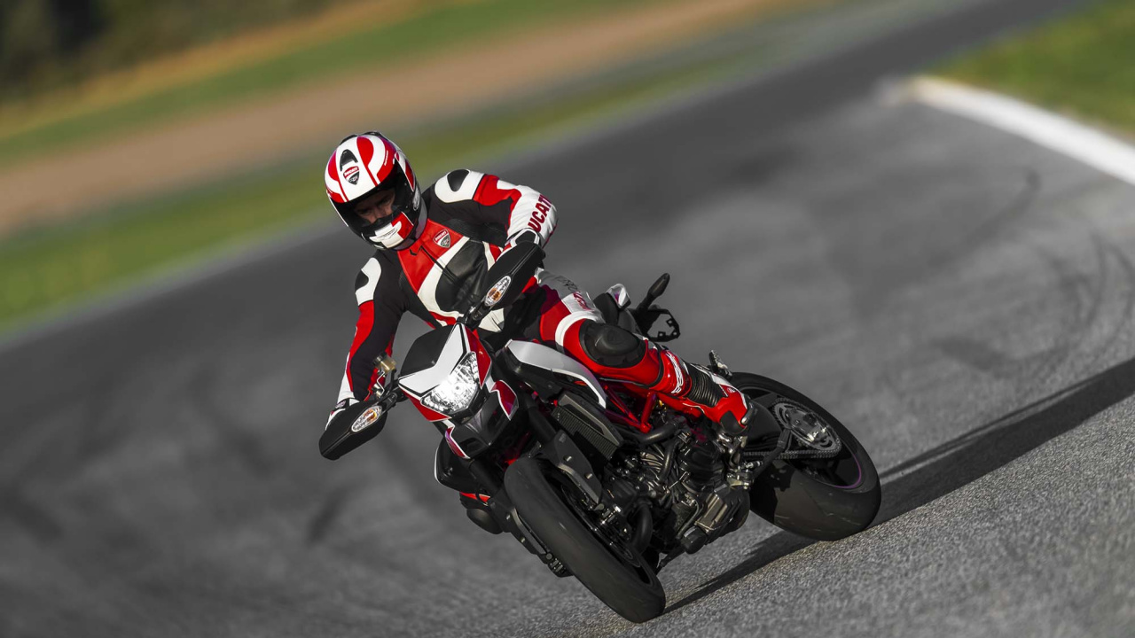 Man in Red and White Racing Suit Riding on Black and Red Sports Bike. Wallpaper in 1280x720 Resolution