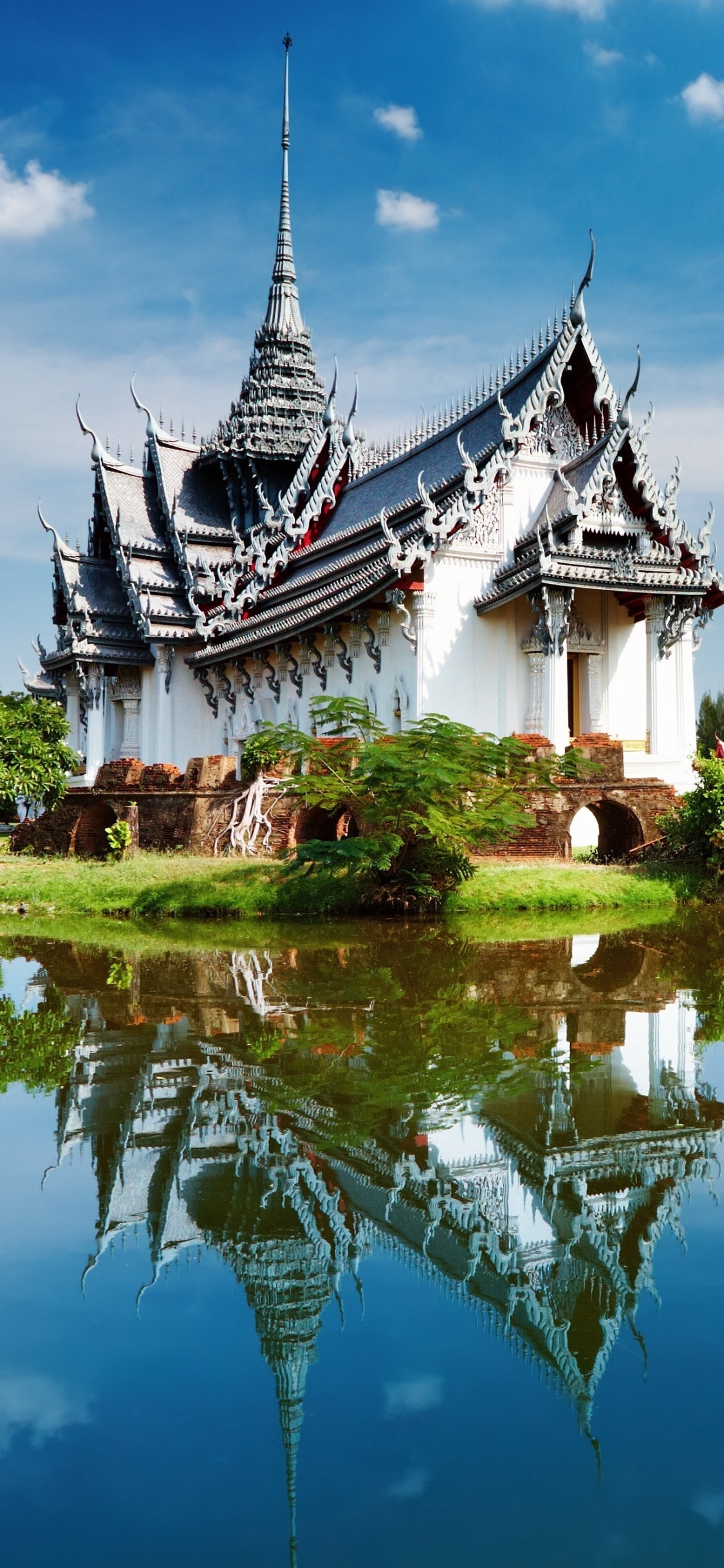 White and Black House Near Body of Water Under Blue Sky During Daytime. Wallpaper in 1125x2436 Resolution