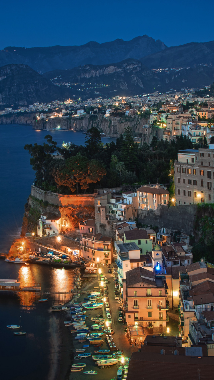 Aerial View of City Buildings Near Body of Water During Night Time. Wallpaper in 750x1334 Resolution