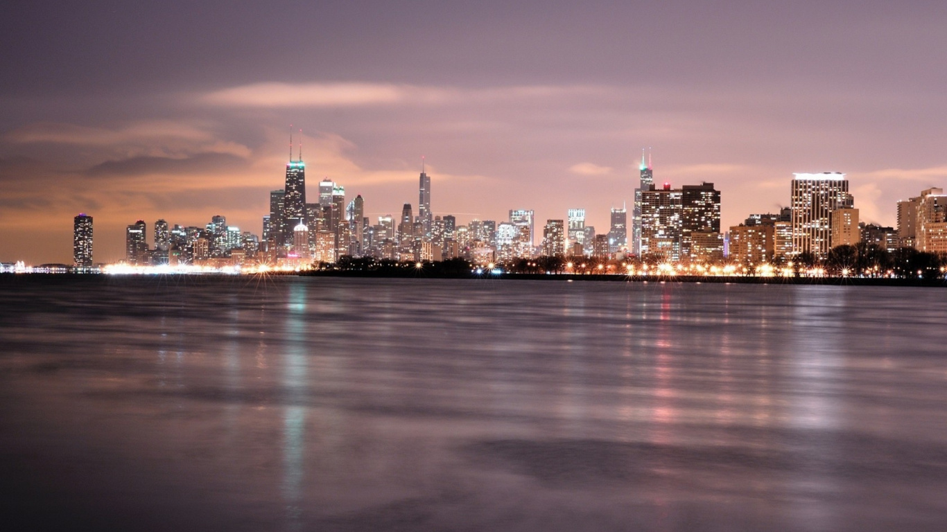 Skyline Der Stadt Über Gewässer Während Der Nacht. Wallpaper in 1366x768 Resolution