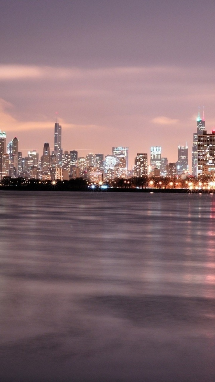 City Skyline Across Body of Water During Night Time. Wallpaper in 720x1280 Resolution