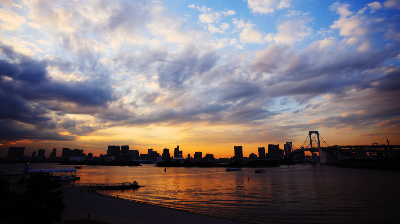 Silhouette of City Buildings Near Body of Water During Sunset. Wallpaper in 1366x768 Resolution