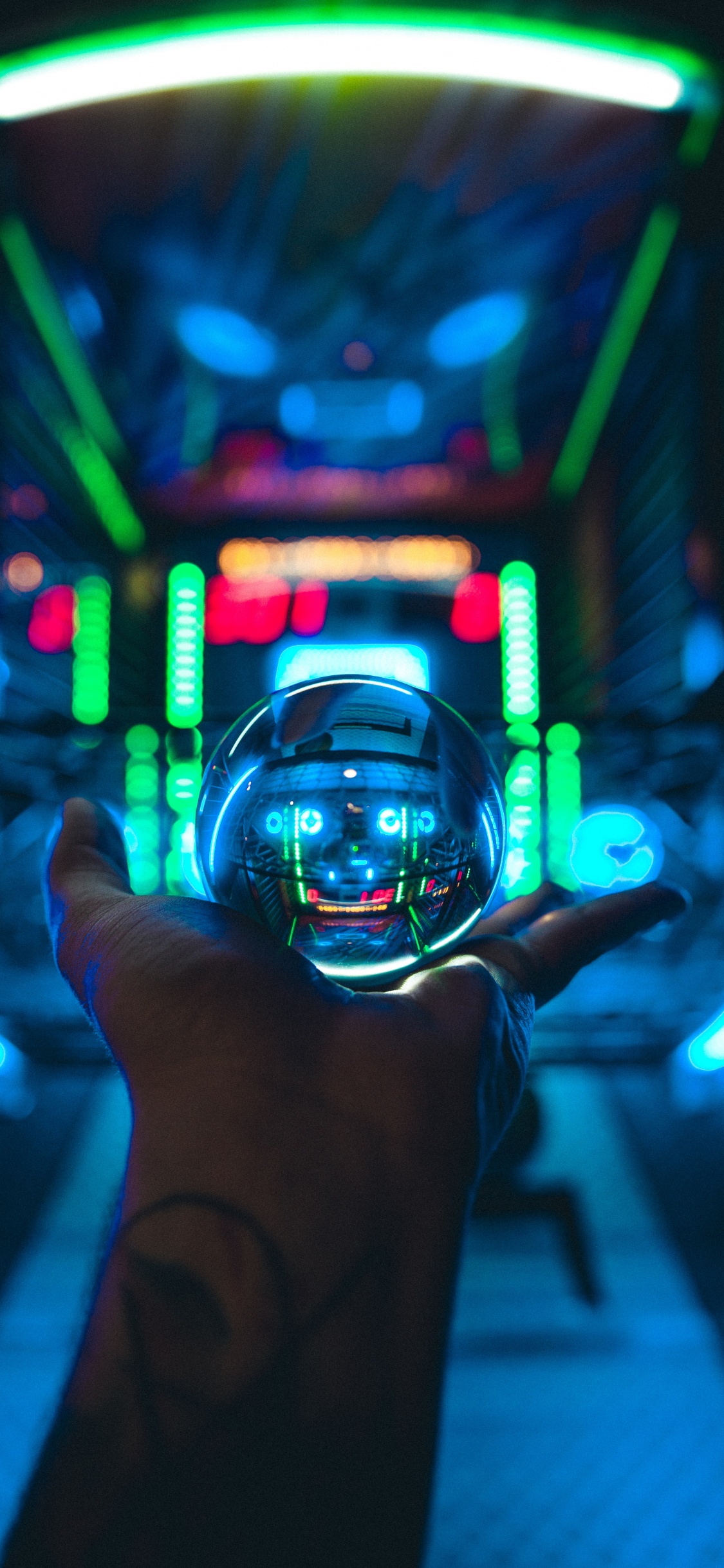 Persona Sosteniendo Una Bola de Cristal Transparente. Wallpaper in 1125x2436 Resolution