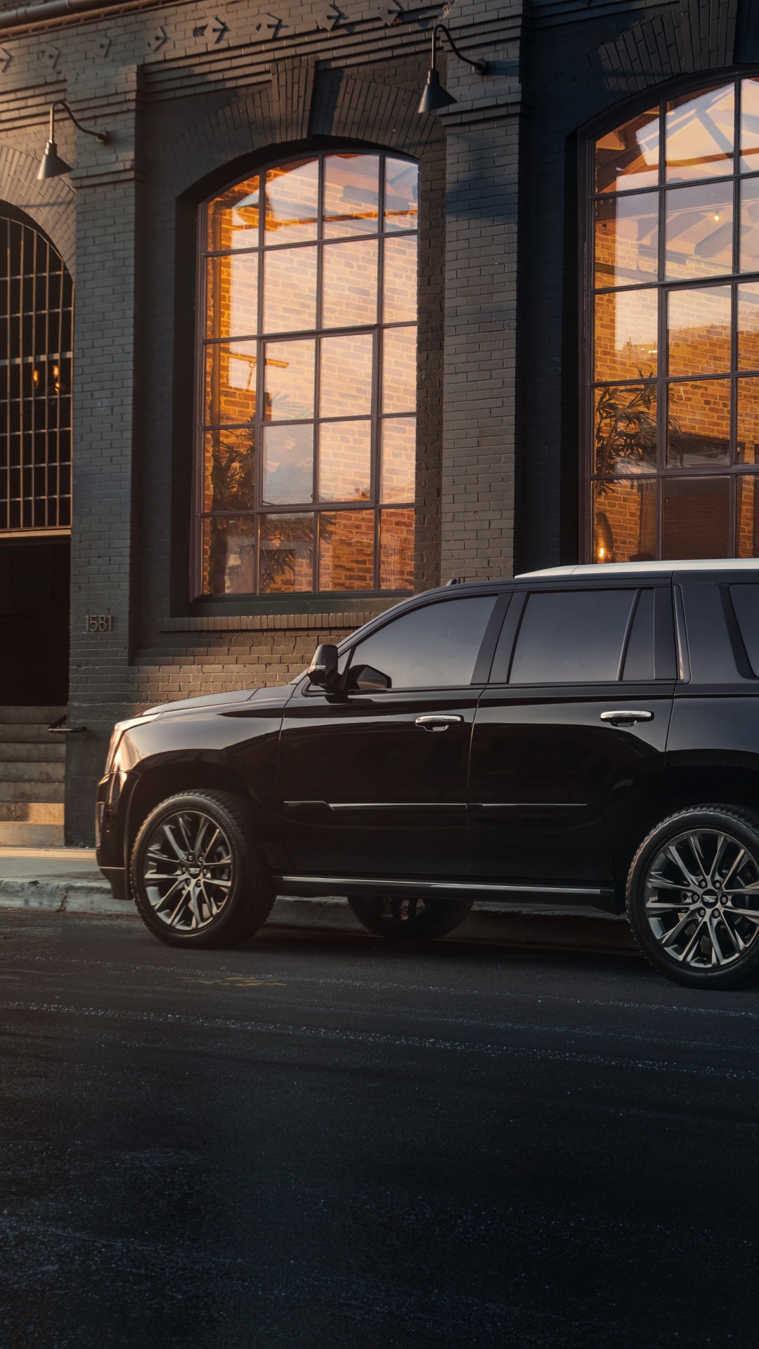 Black Suv Parked in Front of Brown Building. Wallpaper in 1080x1920 Resolution
