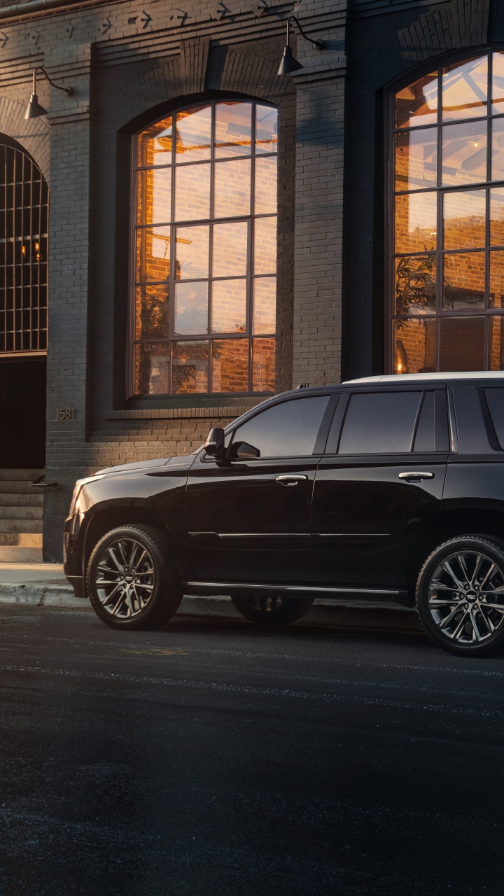 Black Suv Parked in Front of Brown Building. Wallpaper in 720x1280 Resolution