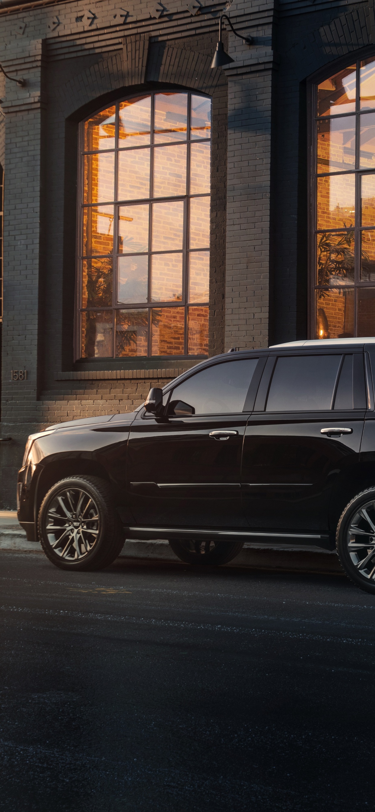 Suv Noir Garé Devant le Bâtiment Marron. Wallpaper in 1242x2688 Resolution