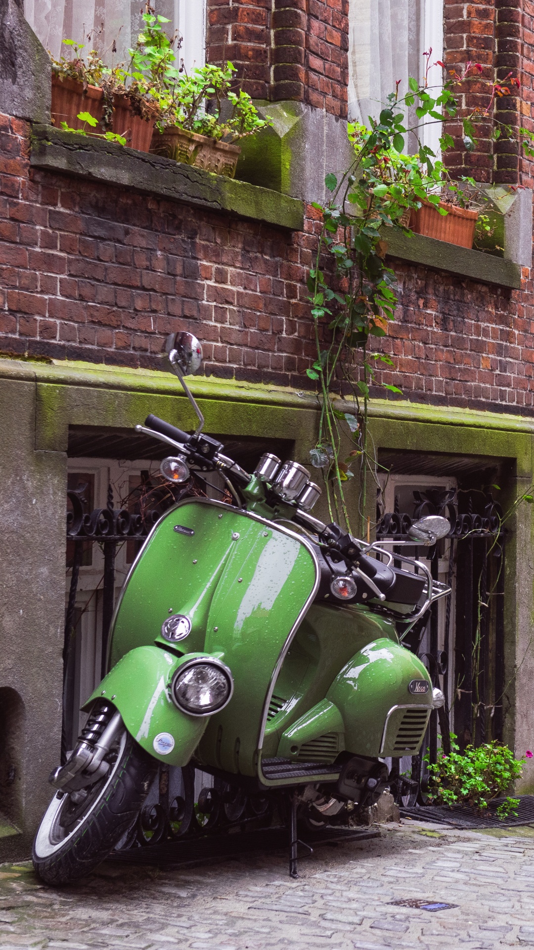 Green Motorcycle Parked Beside Brown Brick Building. Wallpaper in 1080x1920 Resolution