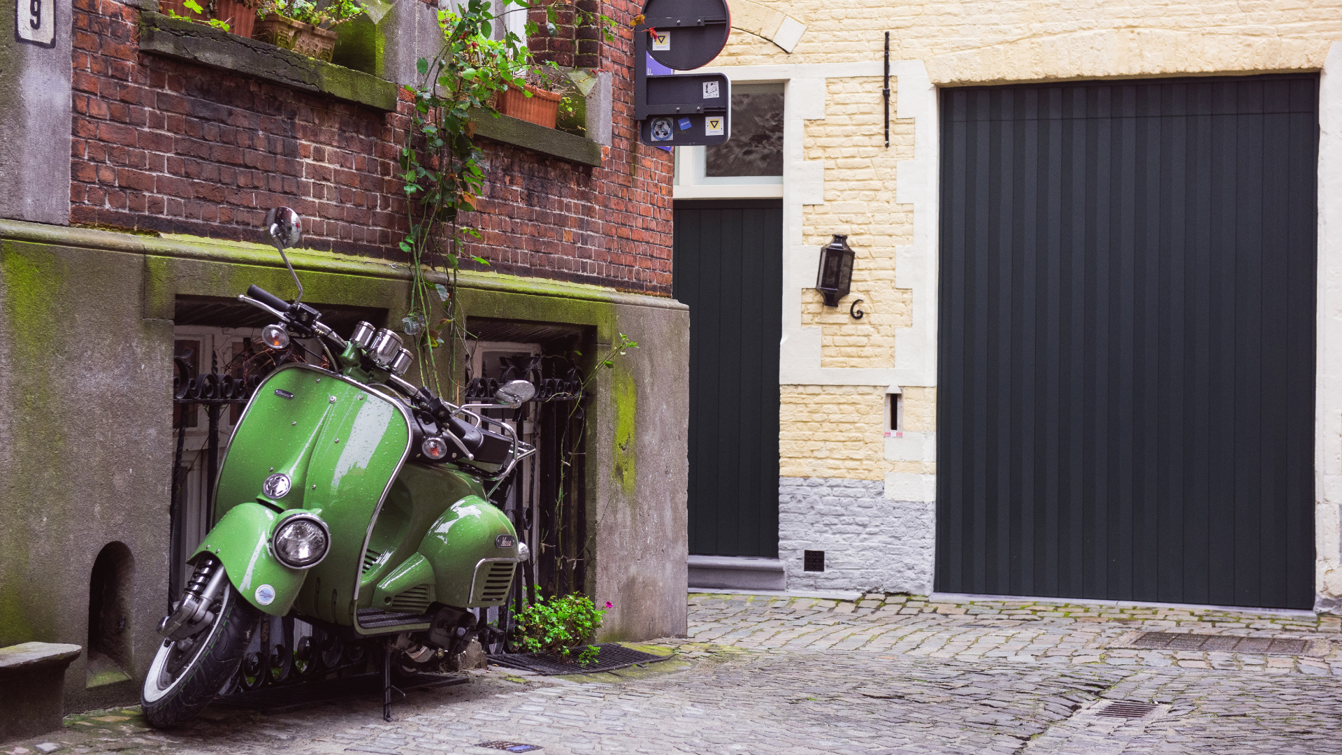 Grünes Motorrad Neben Braunem Backsteingebäude Geparkt. Wallpaper in 1920x1080 Resolution