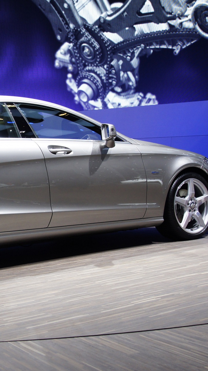 Silver Sedan Parked on White Floor. Wallpaper in 720x1280 Resolution