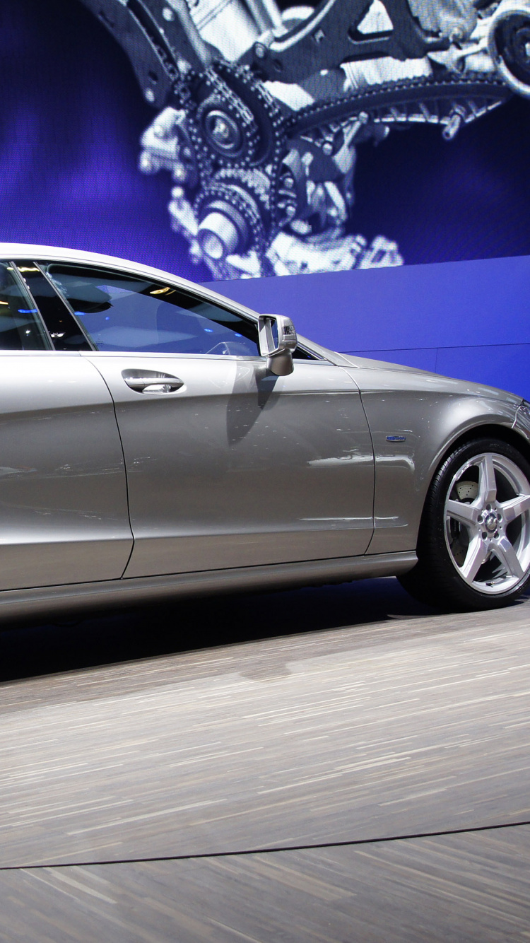 Silver Sedan Parked on White Floor. Wallpaper in 750x1334 Resolution
