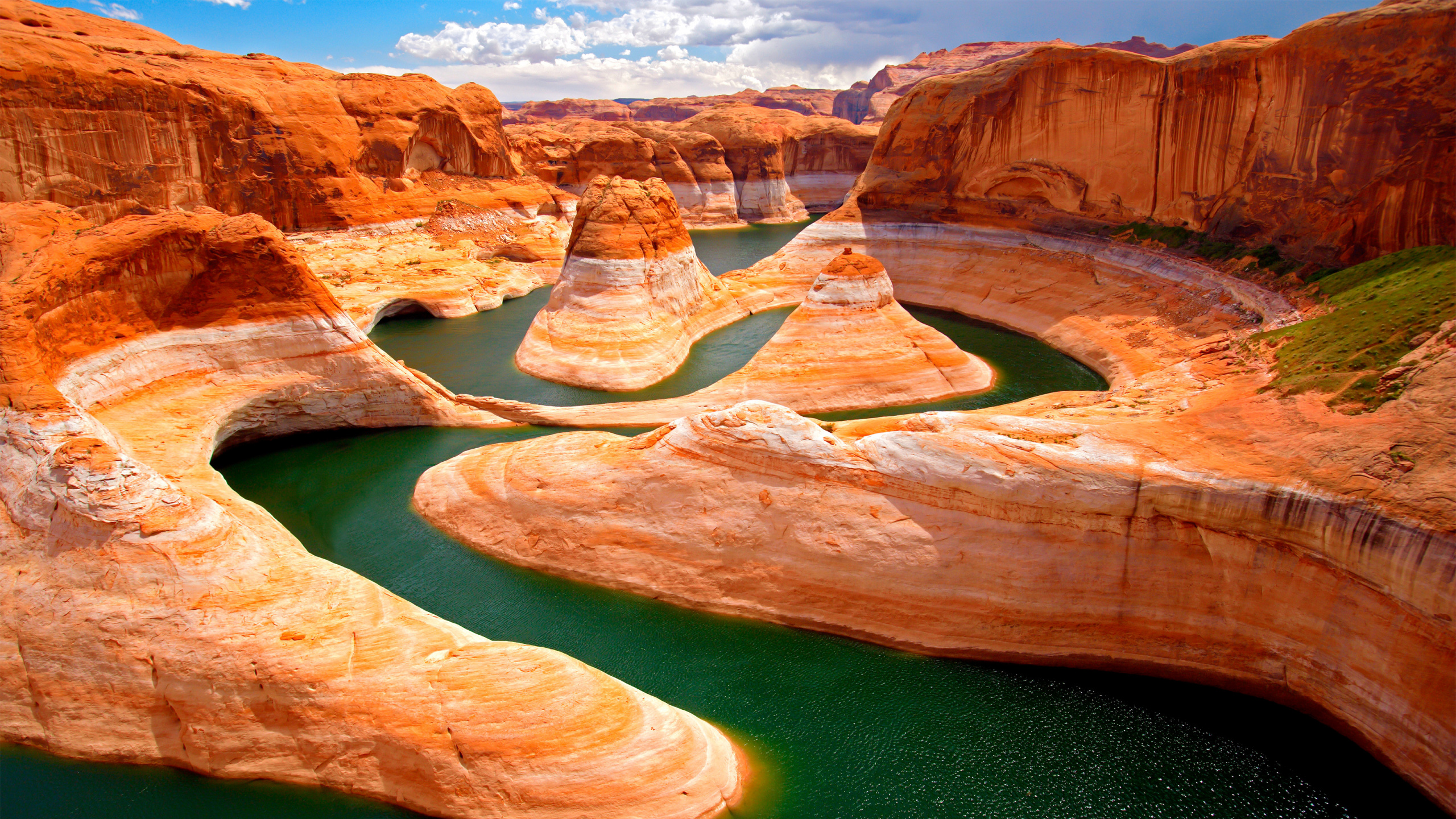 Brown Rock Formation Near Green Water. Wallpaper in 2560x1440 Resolution