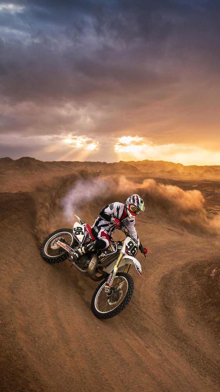 Man Riding Motocross Dirt Bike on Brown Sand During Daytime. Wallpaper in 750x1334 Resolution