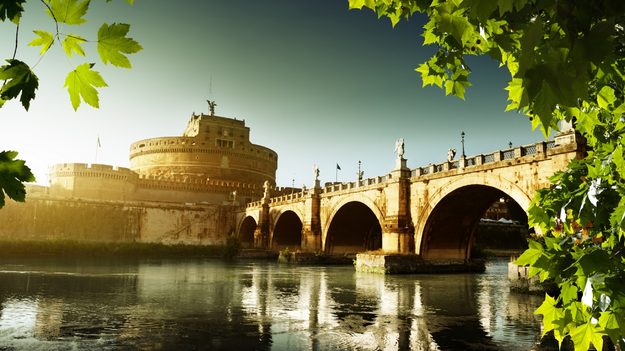 Brown Concrete Building Near Body of Water During Daytime. Wallpaper in 1280x720 Resolution