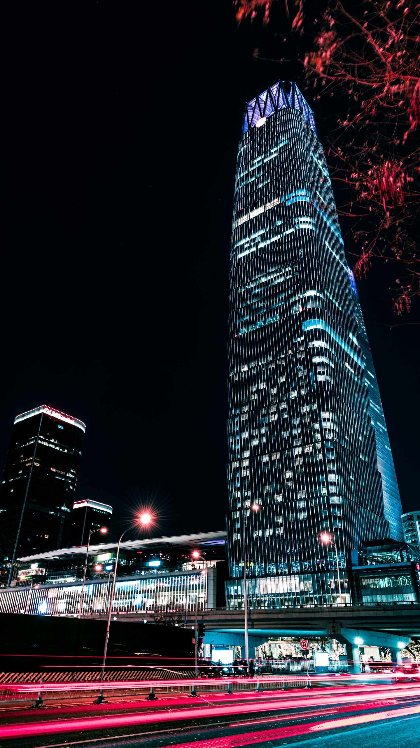 Blaues Und Schwarzes Hochhaus Während Der Nacht. Wallpaper in 1440x2560 Resolution