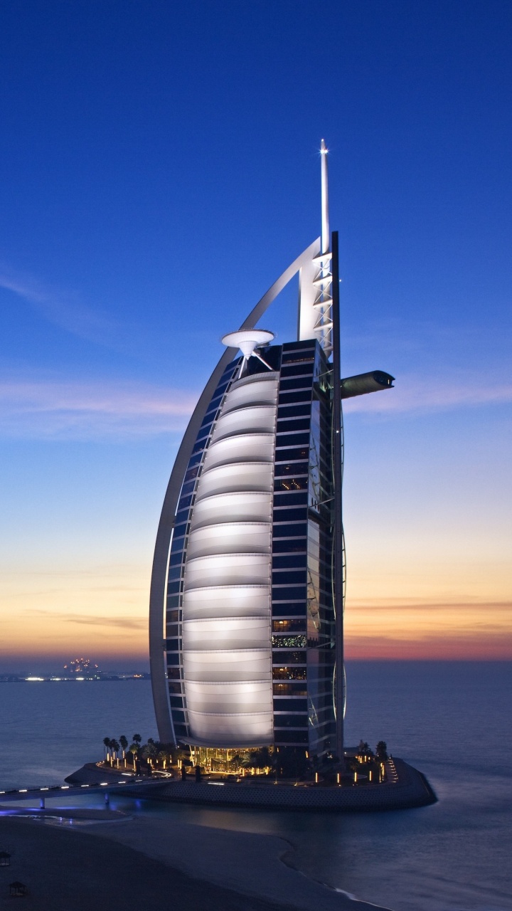 Weißes Und Schwarzes Gebäude in Der Nähe Eines Gewässers Während Der Nacht. Wallpaper in 720x1280 Resolution