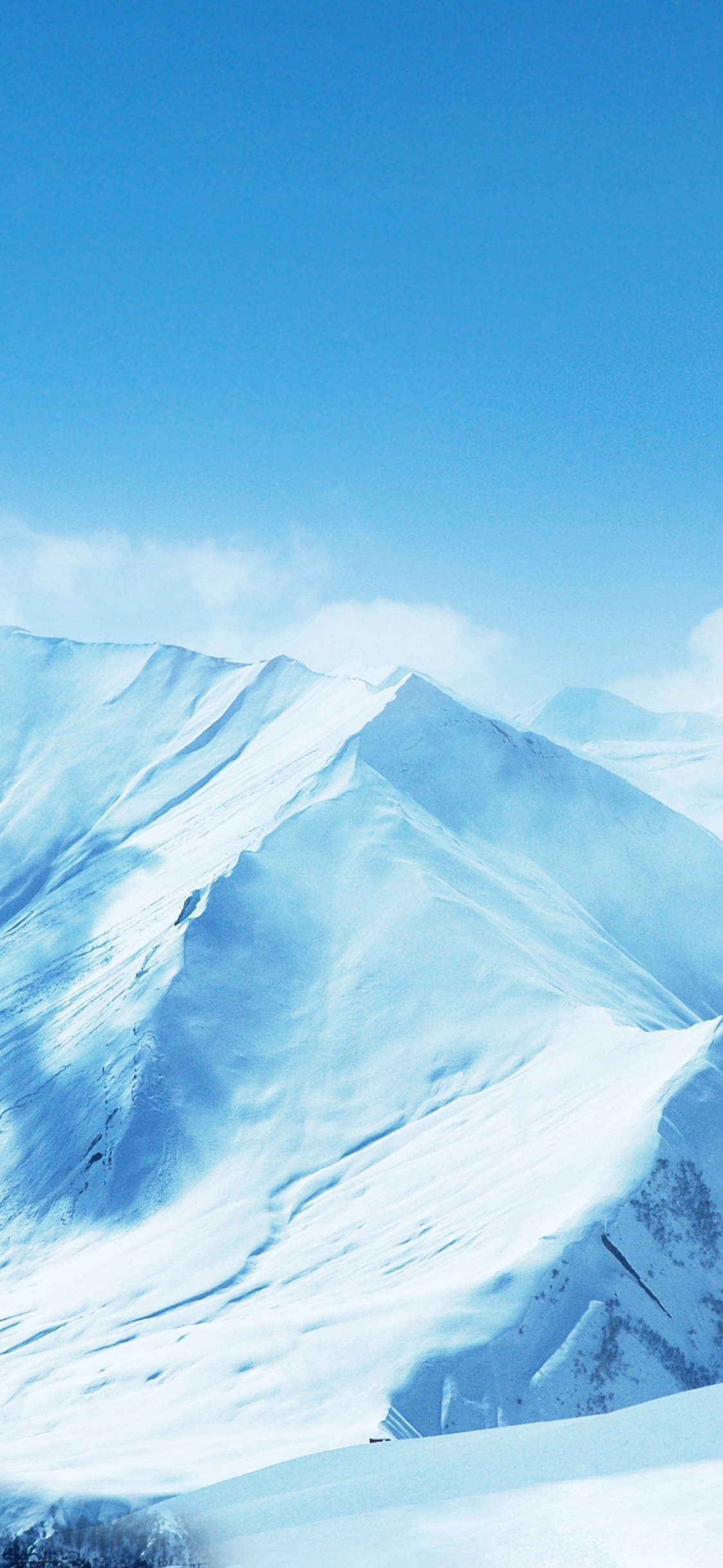 Montaña Cubierta de Nieve Bajo un Cielo Azul. Wallpaper in 1125x2436 Resolution