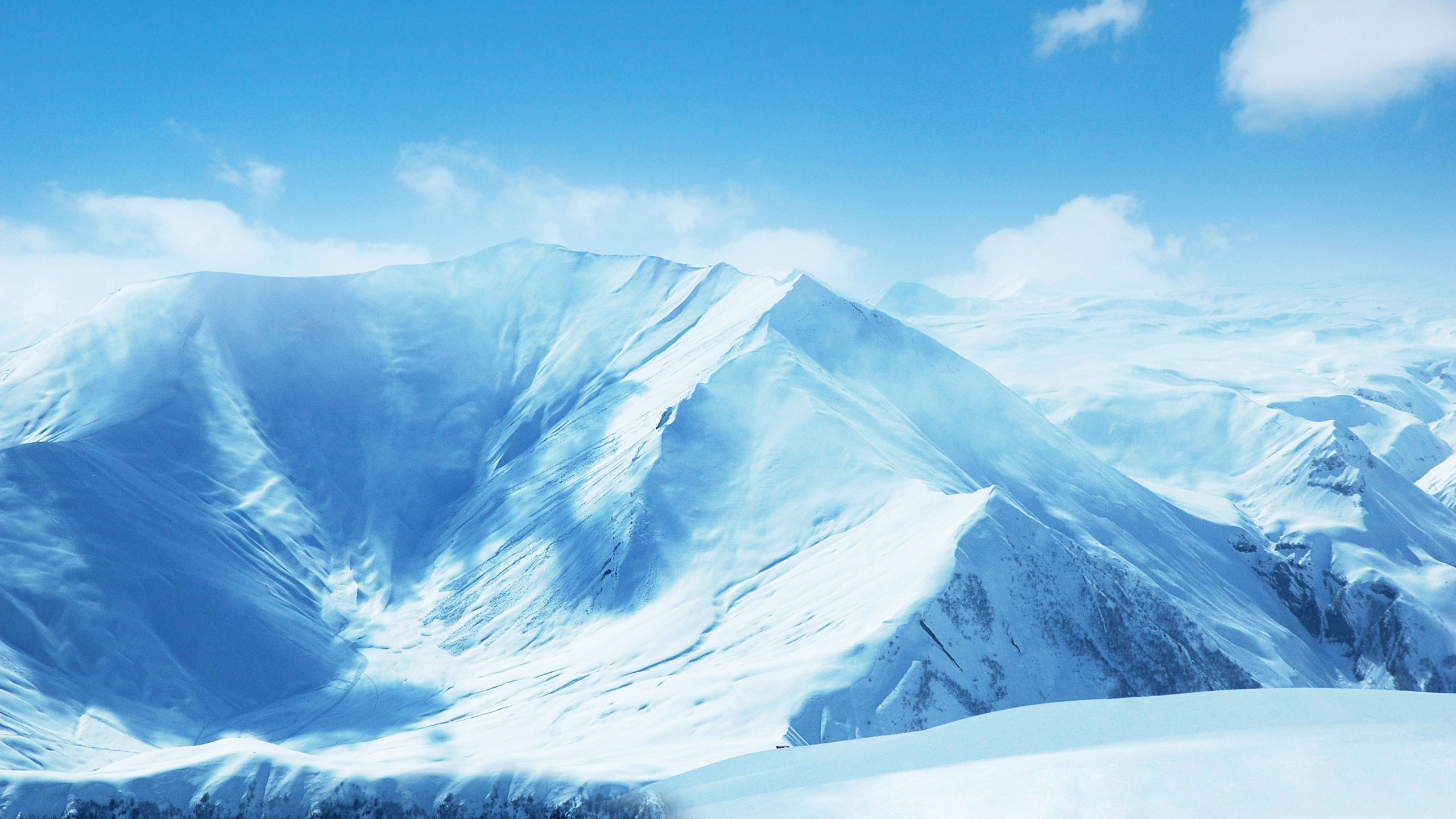 Snow Covered Mountain Under Blue Sky. Wallpaper in 2560x1440 Resolution