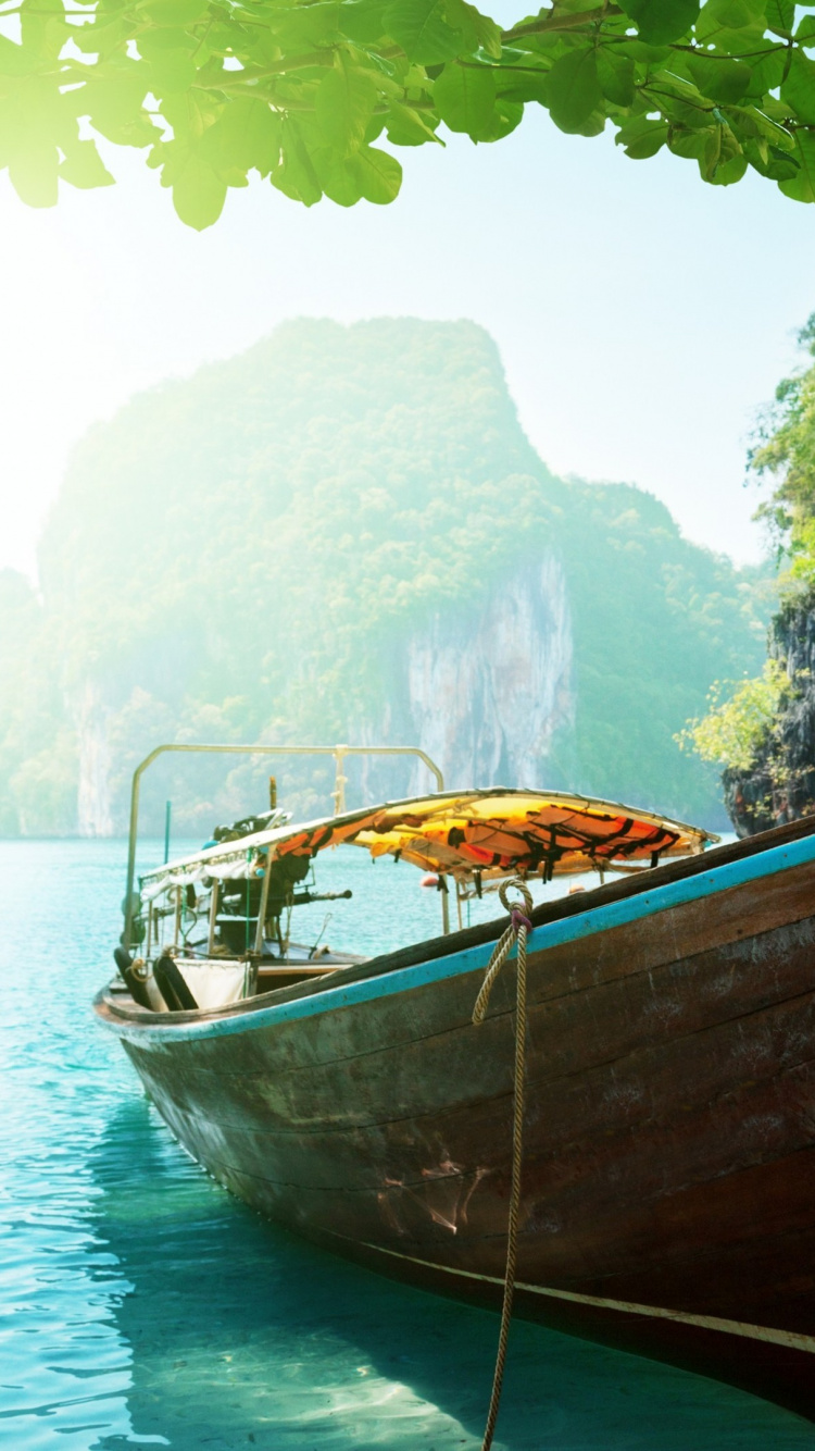 Bateau Marron Sur un Plan D'eau Bleu Pendant la Journée. Wallpaper in 750x1334 Resolution