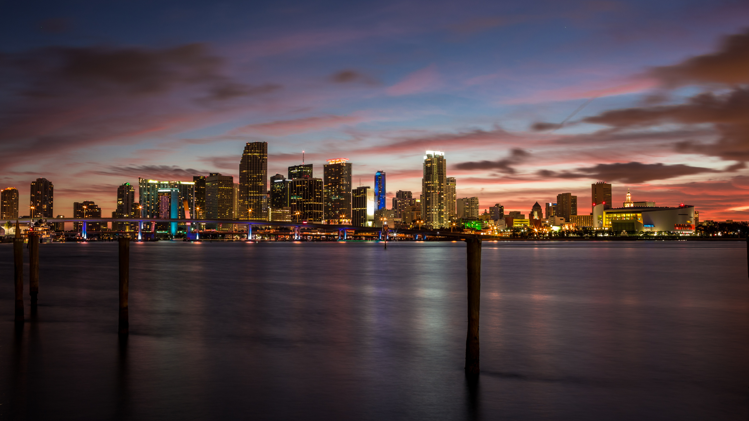 City Skyline Across Body of Water During Sunset. Wallpaper in 2560x1440 Resolution