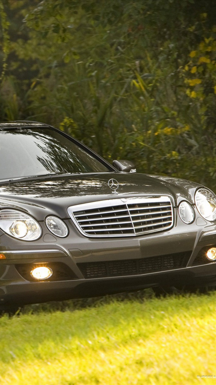 Mercedes Benz Berline Noire Sur Terrain D'herbe Verte Pendant la Journée. Wallpaper in 720x1280 Resolution