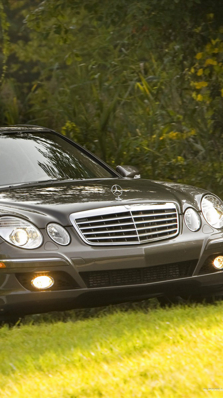 Mercedes Benz Berline Noire Sur Terrain D'herbe Verte Pendant la Journée. Wallpaper in 750x1334 Resolution