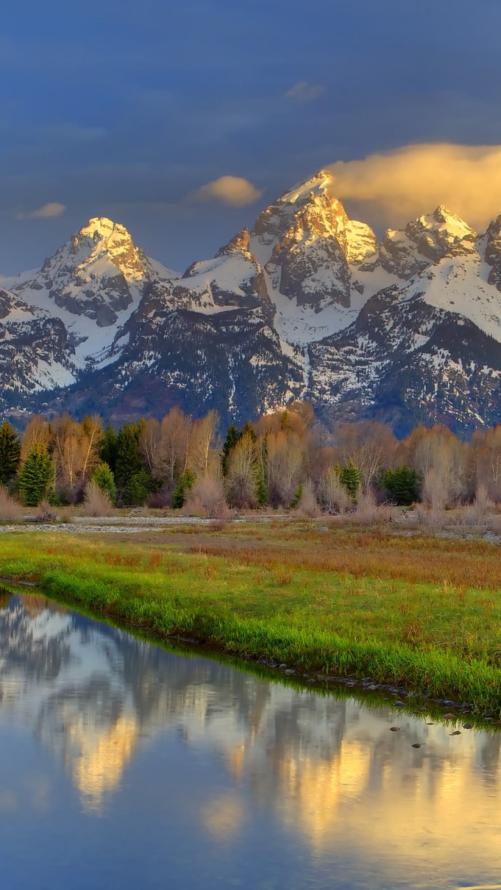 Grüne Wiese in Der Nähe Von See Und Schneebedeckten Bergen Tagsüber. Wallpaper in 720x1280 Resolution