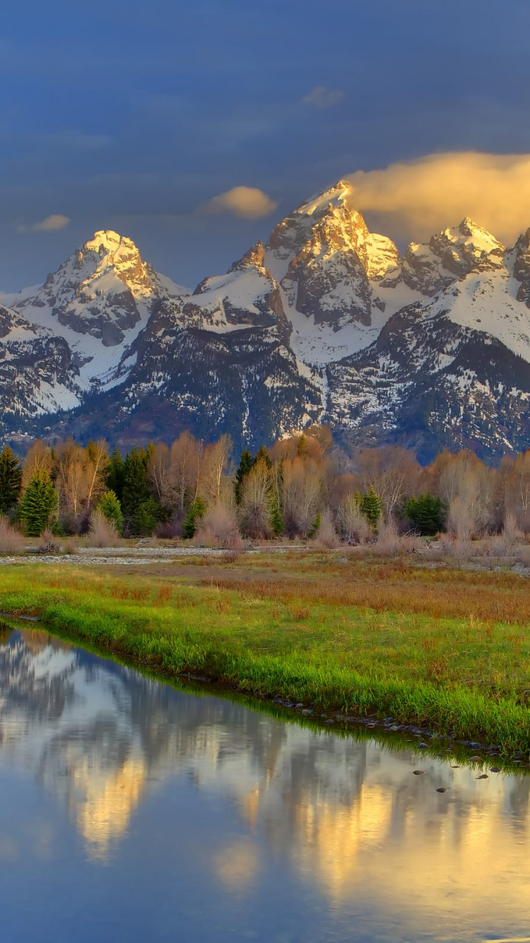 Grüne Wiese in Der Nähe Von See Und Schneebedeckten Bergen Tagsüber. Wallpaper in 750x1334 Resolution