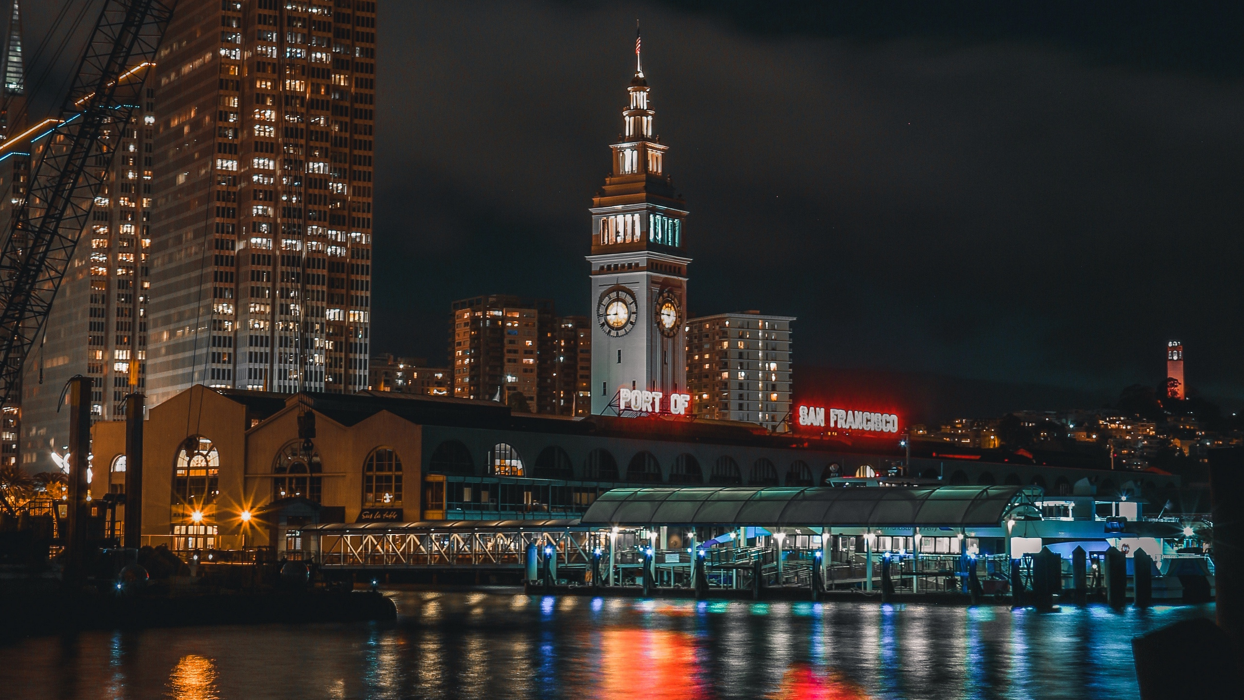Lighted High Rise Building Near Body of Water During Night Time. Wallpaper in 2560x1440 Resolution