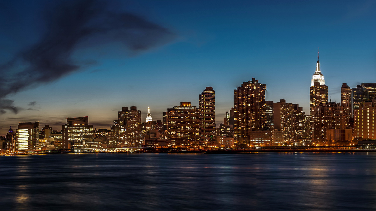 Skyline Der Stadt Über Gewässer Während Der Nacht. Wallpaper in 1280x720 Resolution