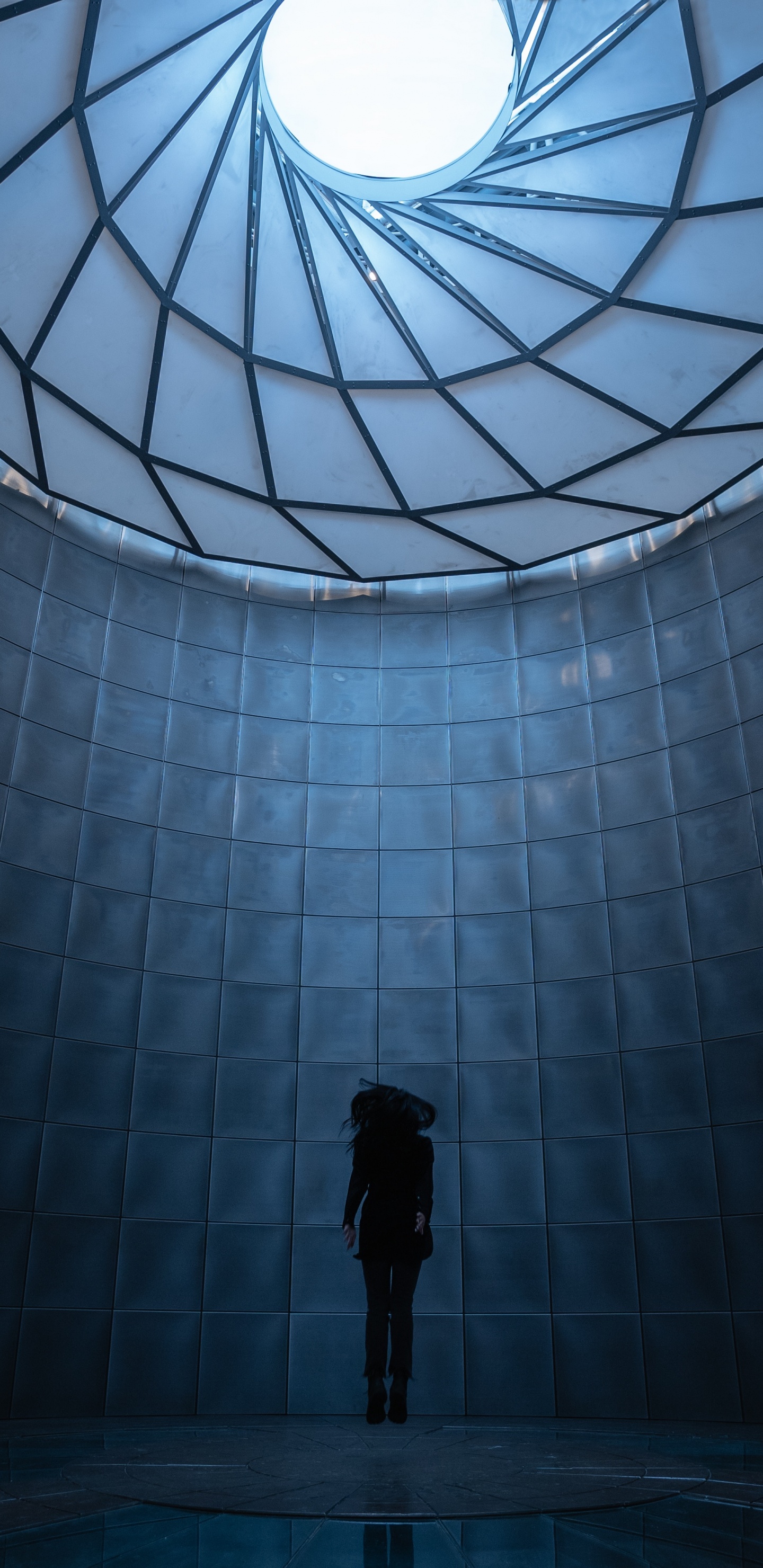 Mann in Schwarzer Jacke Steht Vor Glaswand. Wallpaper in 1440x2960 Resolution