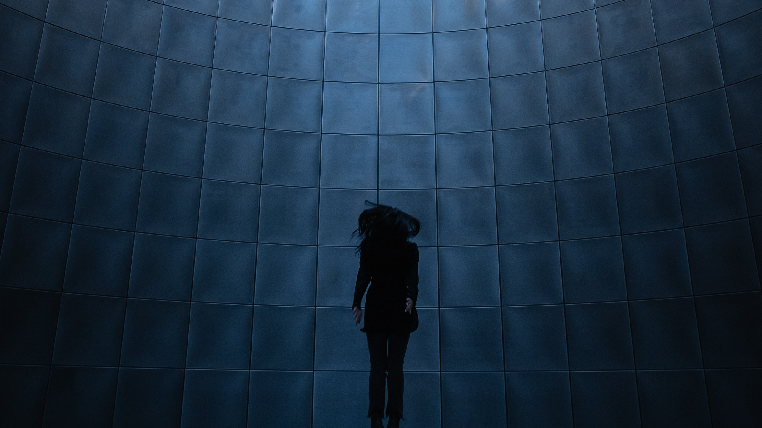 Man in Black Jacket Standing in Front of Glass Wall. Wallpaper in 2560x1440 Resolution