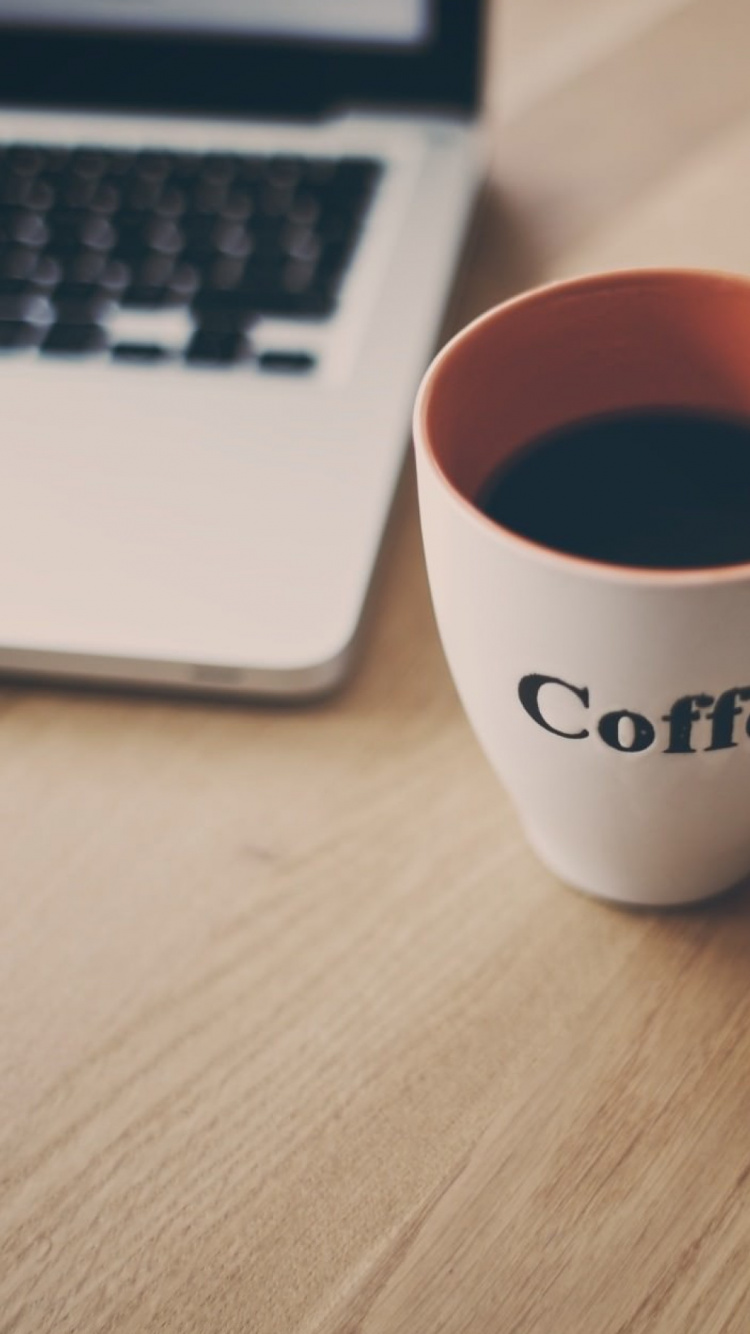White Ceramic Mug Beside Macbook Pro. Wallpaper in 750x1334 Resolution