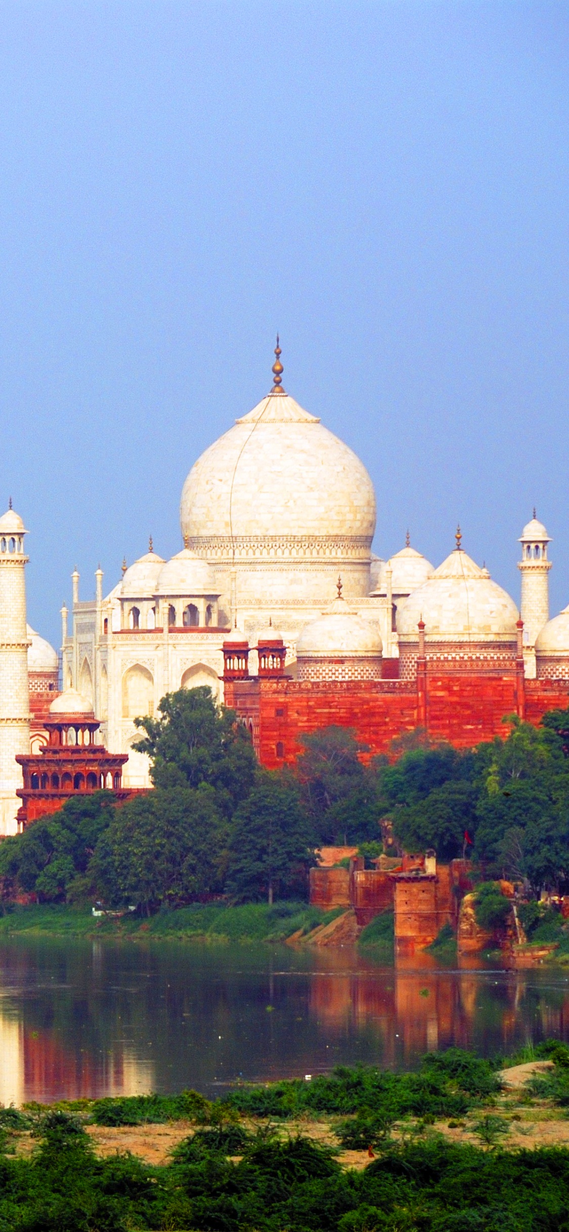 White and Brown Concrete Building Near Body of Water During Daytime. Wallpaper in 1125x2436 Resolution