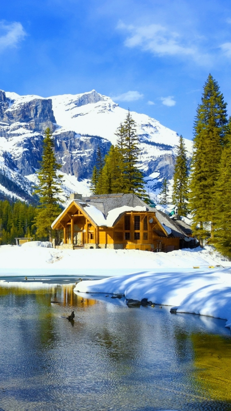 Braunes Holzhaus in Der Nähe Von See Und Schneebedecktem Berg Tagsüber. Wallpaper in 750x1334 Resolution