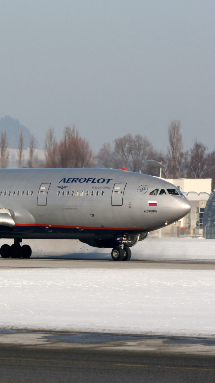 Avion de Ligne Blanc et Rouge à L'aéroport Pendant la Journée. Wallpaper in 750x1334 Resolution