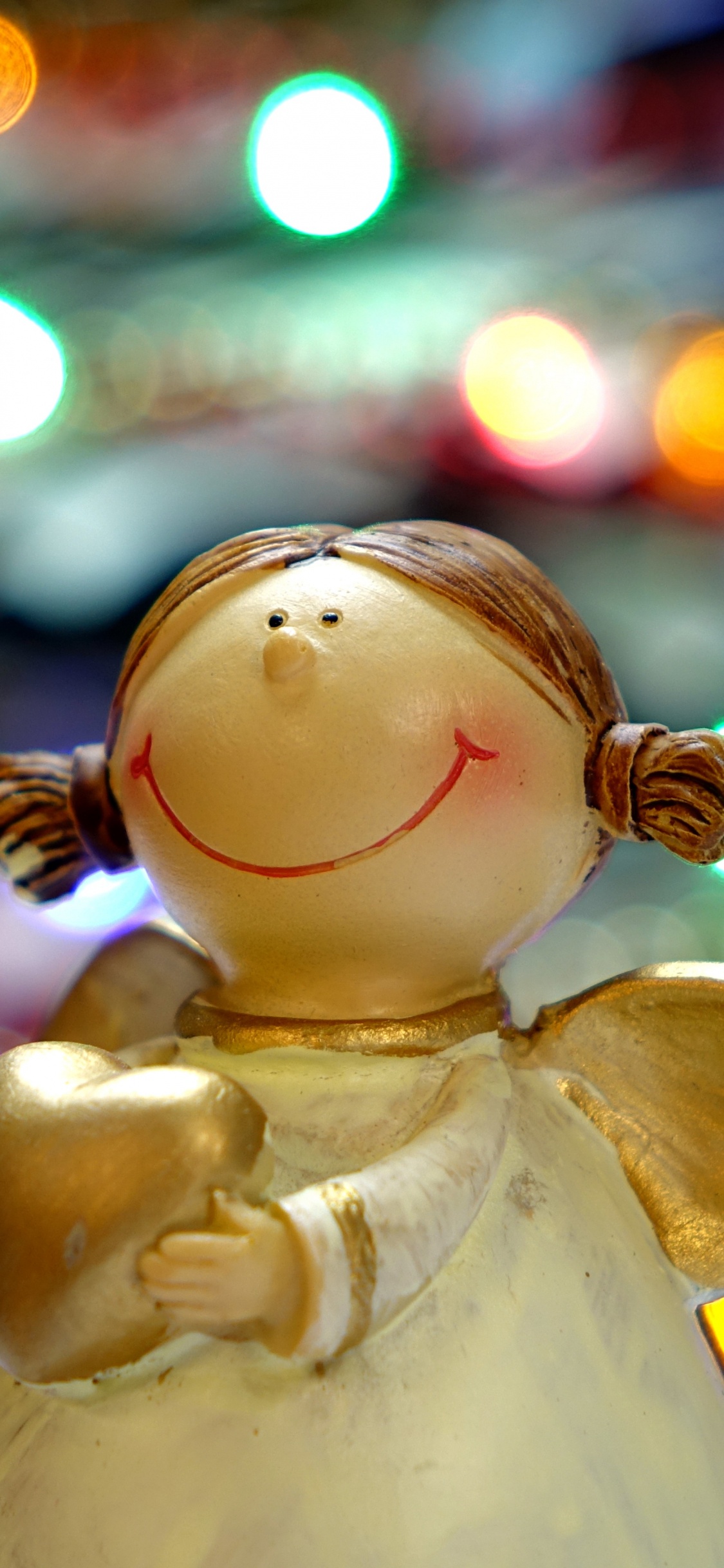 White Angel Ceramic Figurine in Bokeh Photography. Wallpaper in 1125x2436 Resolution