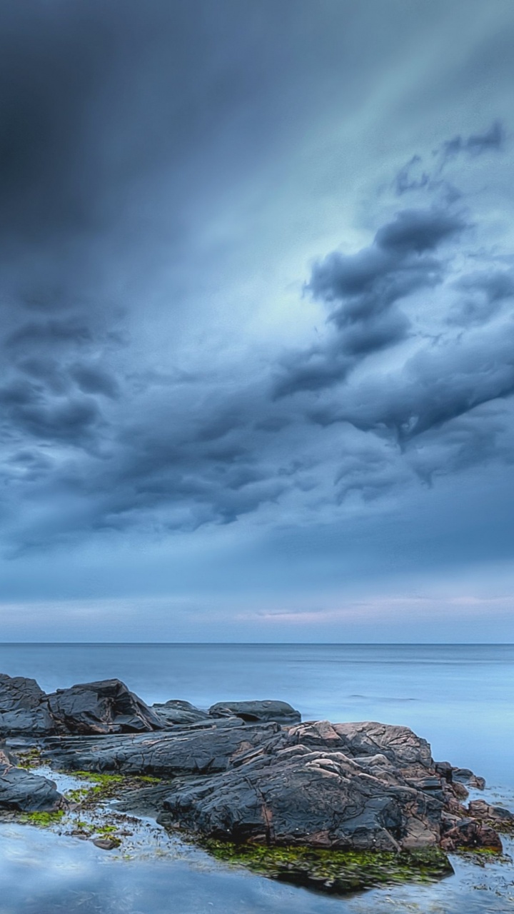 Gray Rocky Shore Under Gray Clouds. Wallpaper in 720x1280 Resolution