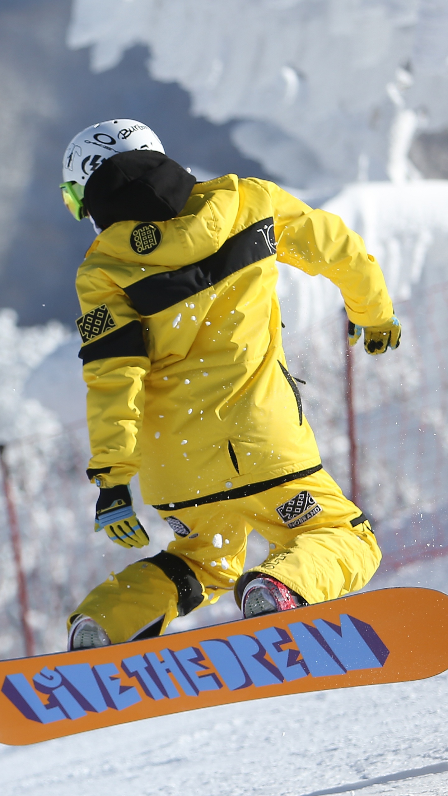 Hombre de Chaqueta Amarilla y Casco Negro Montando en Snowboard en la Montaña Cubierta de Nieve Durante el Día. Wallpaper in 1440x2560 Resolution