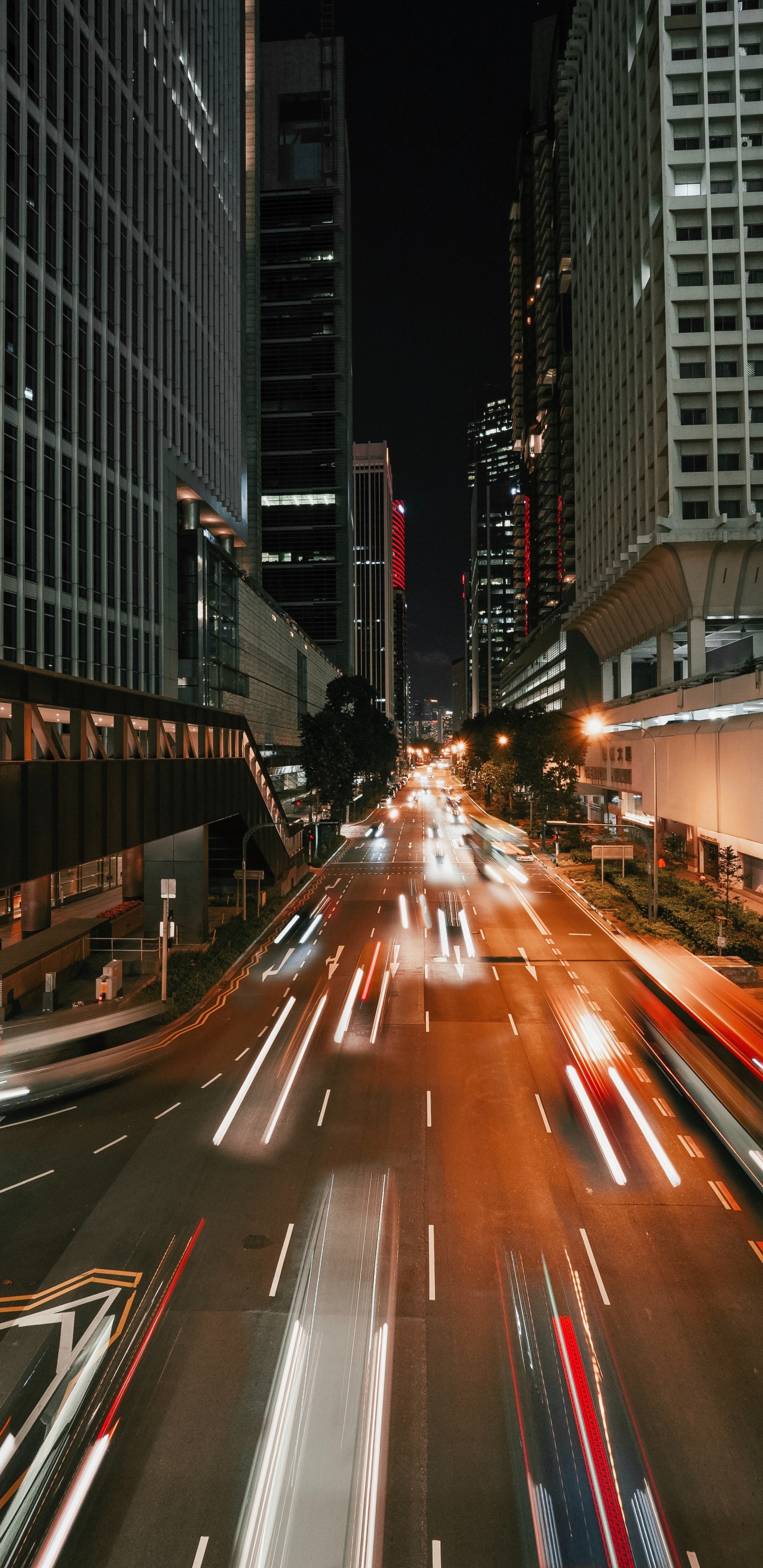 Coches en la Carretera Entre Edificios de Gran Altura Durante la Noche. Wallpaper in 1440x2960 Resolution