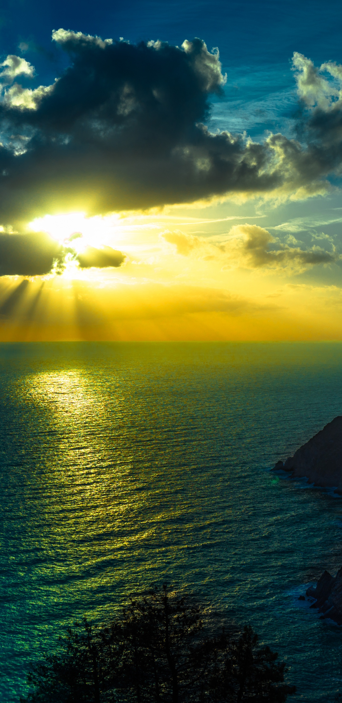 Tagsüber Grüner Berg Neben Einem Gewässer. Wallpaper in 1440x2960 Resolution