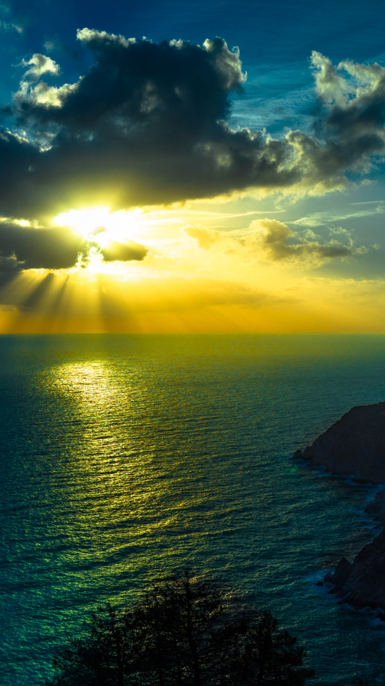 Tagsüber Grüner Berg Neben Einem Gewässer. Wallpaper in 750x1334 Resolution