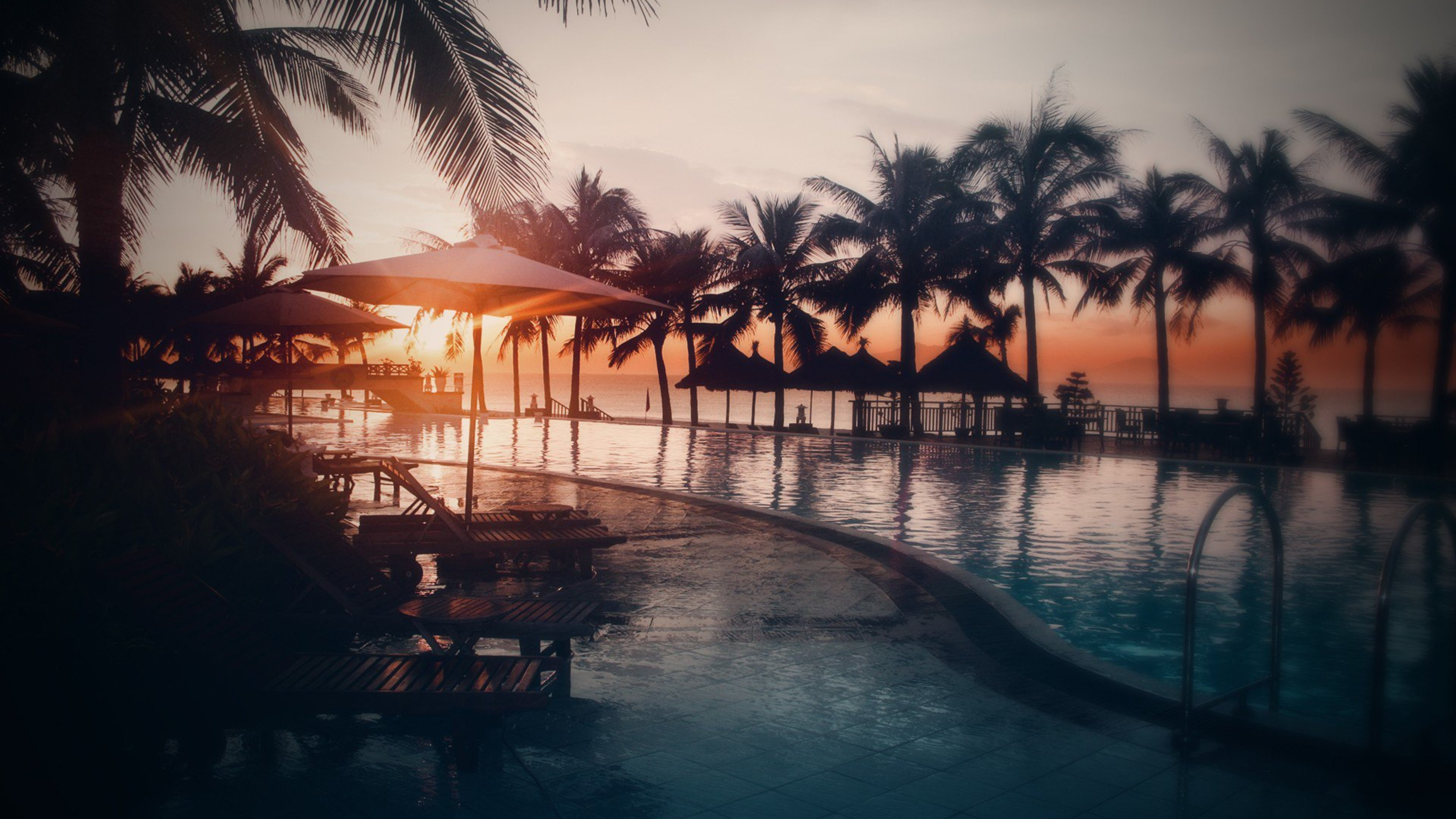 Brown Wooden Beach Lounge Chairs Near Beach During Sunset. Wallpaper in 3840x2160 Resolution