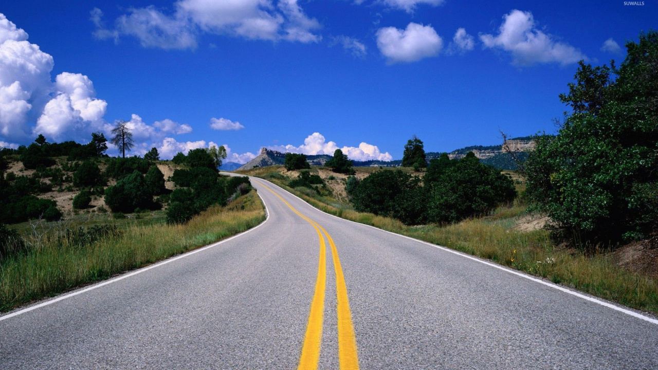 Gray Concrete Road Between Green Grass Field Under Blue Sky and White Clouds During Daytime. Wallpaper in 1280x720 Resolution