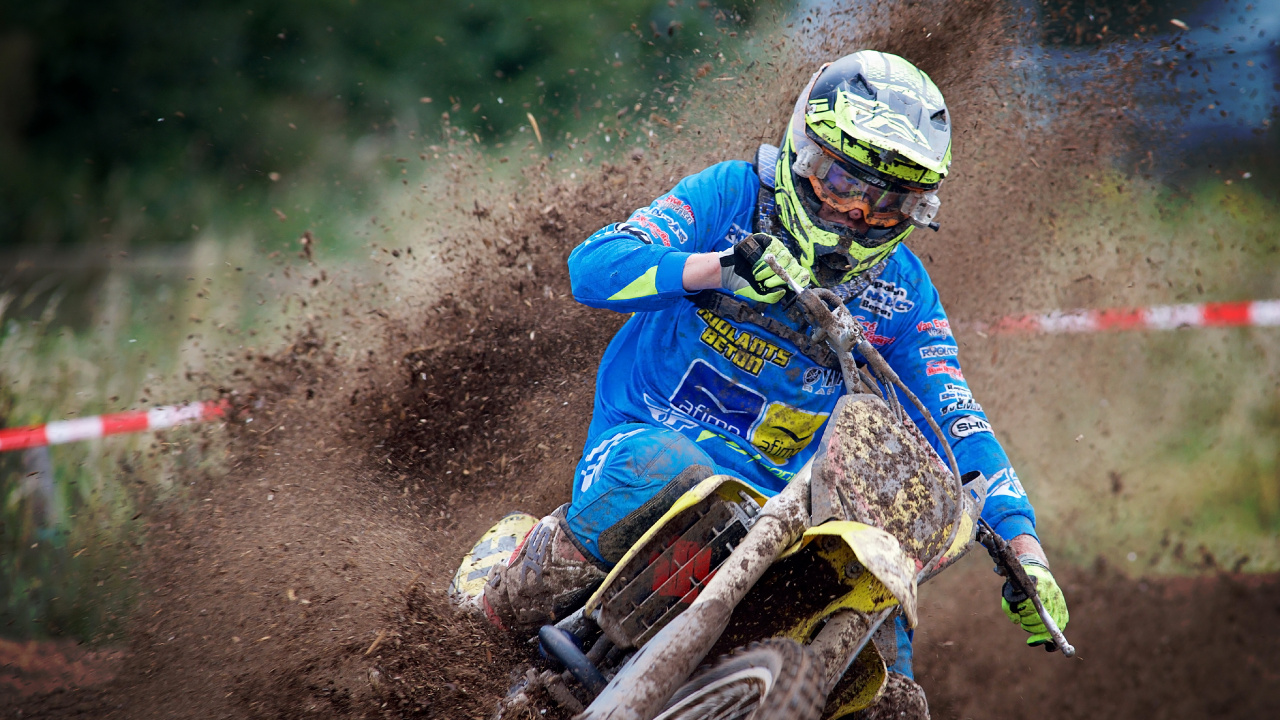 Man in Blue and Red Jacket Riding on Motocross Dirt Bike. Wallpaper in 1280x720 Resolution