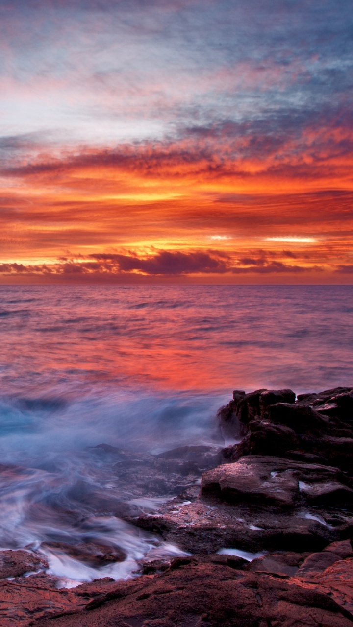 Les Vagues de L'océan S'écrasent Sur Les Rochers au Coucher du Soleil. Wallpaper in 720x1280 Resolution